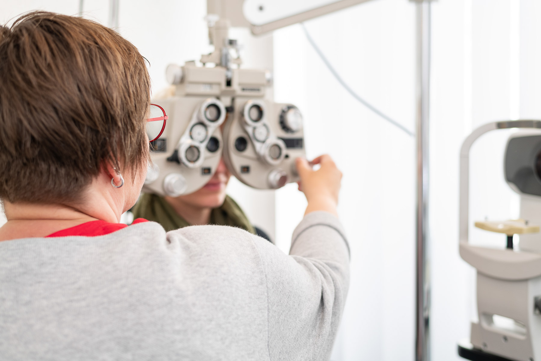 Die Dioptrinanzahl wird von einer Augenoptikerin mit einem Messgerät gemessen