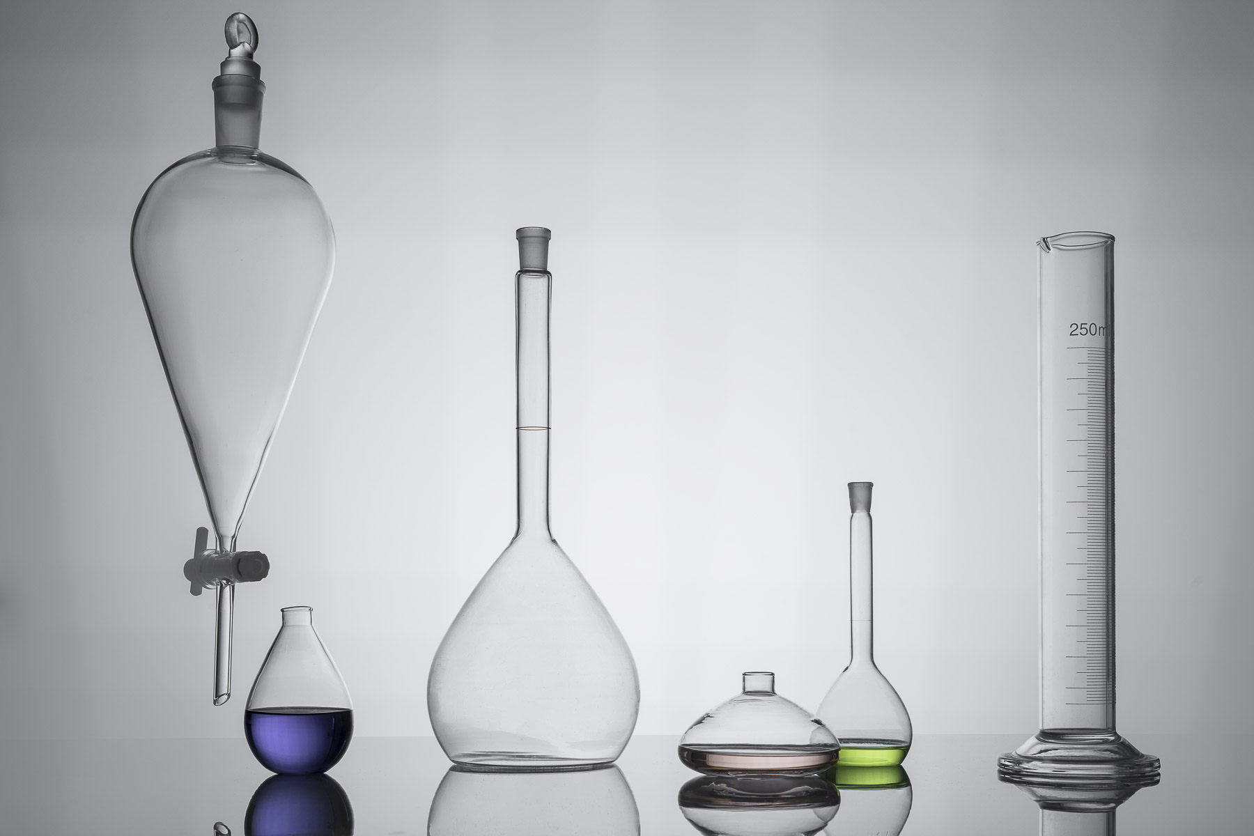 Aufgereite Gläser zum Thema Labor für die Kosmetikbranche. In Gläsern sind farbige Flüssigkeiten. Seperationglas.