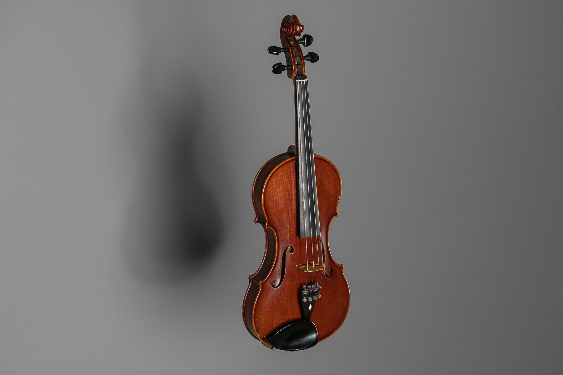Eine Geige bzw. Violine vor grauem Hintergrund im Fotostudio fotografiert