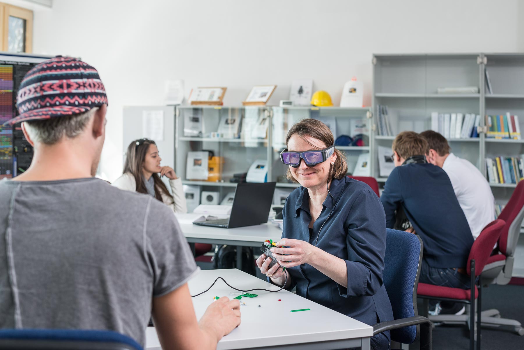 Die Dozentin lehrt über eine Technik mit Brille den Student*innen sein Wissen im Einzelgespräch.