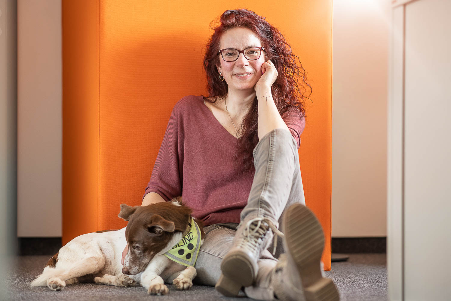 Mitarbeiterportrait mit Hund im Büro, sitzend